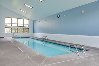 a swimming pool with a concrete floor and blue walls